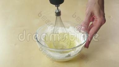 用手提搅拌器在玻璃碗中配制奶油